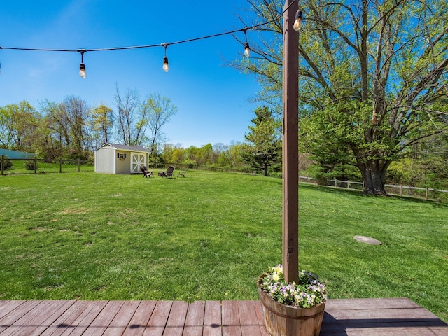 view of yard with an outdoor structure, a fenced backyard, and a shed