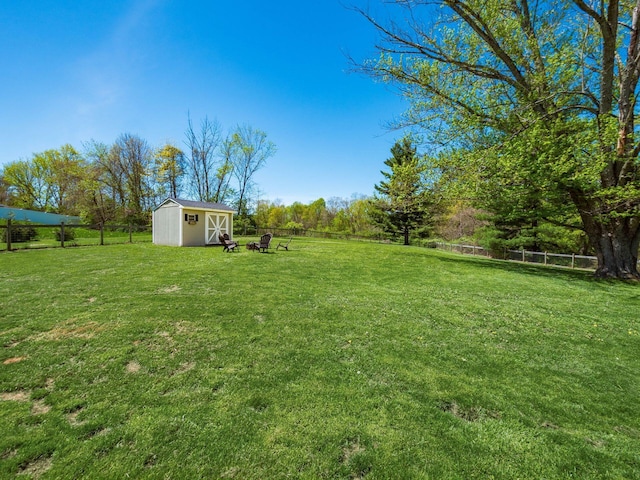 view of yard featuring a storage shed, fence, and an outdoor structure
