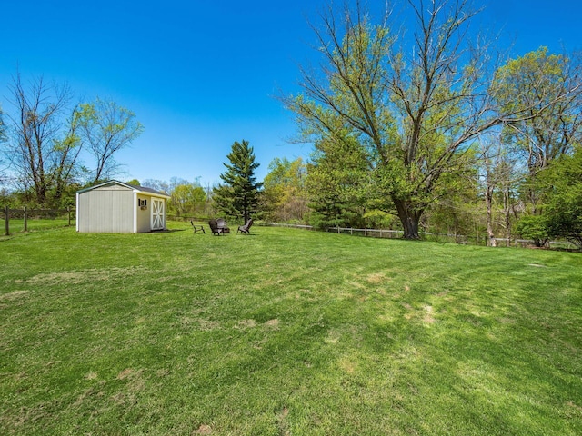 view of yard with an outbuilding, fence, and a storage shed