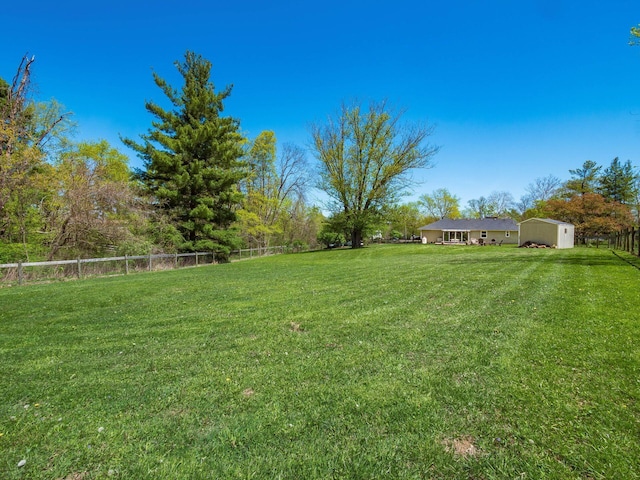 view of yard with fence and an outdoor structure