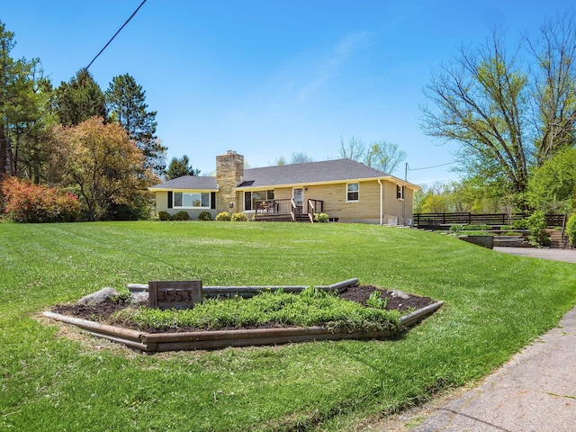 rear view of house with a yard, fence, a wooden deck, and a chimney