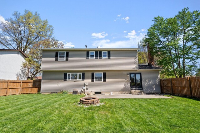 rear view of property with a lawn, a fenced backyard, and a patio area