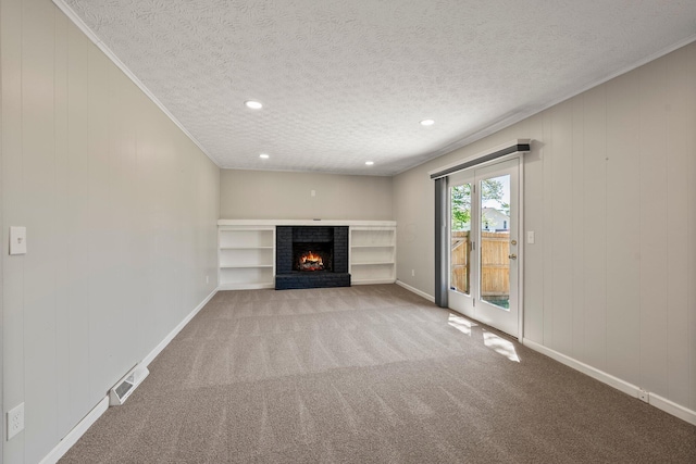 unfurnished living room featuring a brick fireplace, a textured ceiling, carpet, baseboards, and visible vents