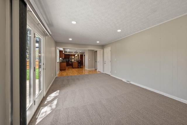 unfurnished room with a textured ceiling, visible vents, baseboards, light carpet, and recessed lighting