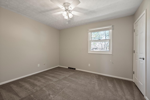 carpeted spare room featuring baseboards, a ceiling fan, a textured ceiling, and visible vents