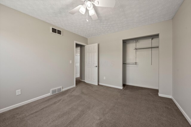 unfurnished bedroom with visible vents, carpet, a textured ceiling, and a closet