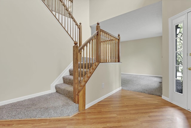 entryway with stairway, baseboards, and wood finished floors
