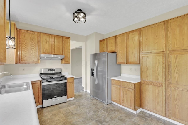 kitchen featuring a sink, under cabinet range hood, light countertops, and appliances with stainless steel finishes