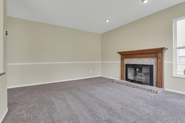 unfurnished living room with a fireplace, carpet flooring, baseboards, and recessed lighting