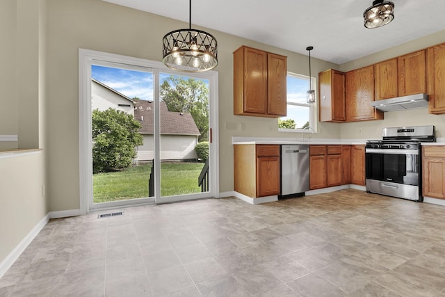 kitchen featuring visible vents, decorative light fixtures, under cabinet range hood, light countertops, and appliances with stainless steel finishes