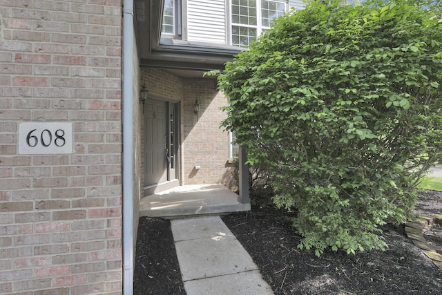 entrance to property featuring brick siding