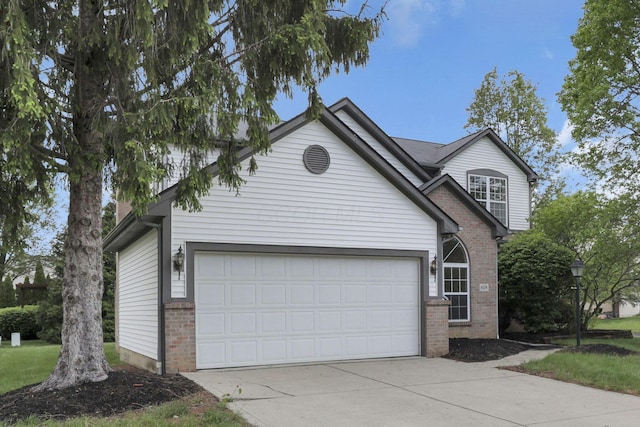 view of front of house with concrete driveway, brick siding, and an attached garage