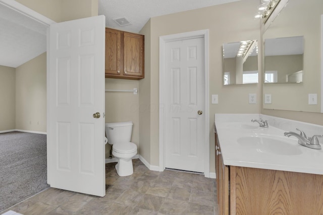 bathroom with toilet, baseboards, visible vents, and a sink