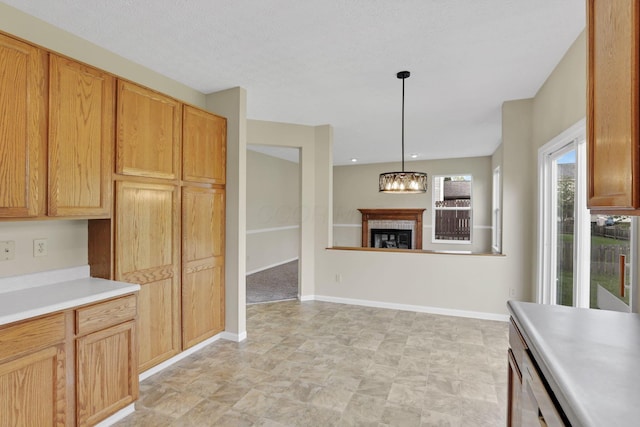 kitchen with baseboards, hanging light fixtures, light countertops, and an inviting chandelier