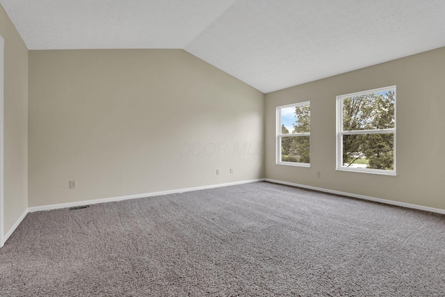 unfurnished room featuring baseboards, carpet, and vaulted ceiling