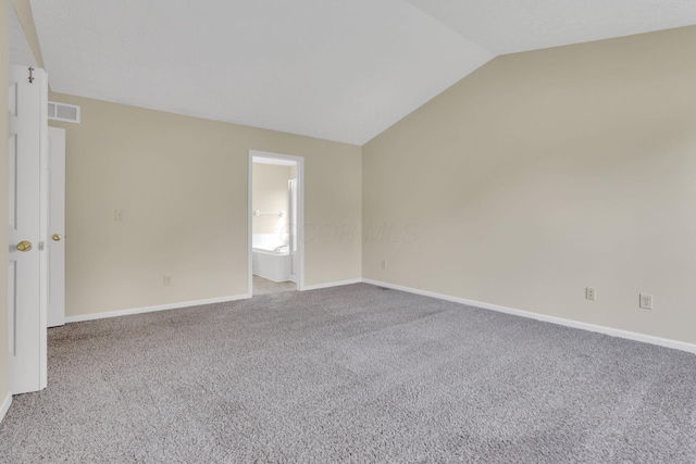 spare room featuring vaulted ceiling, carpet, baseboards, and visible vents