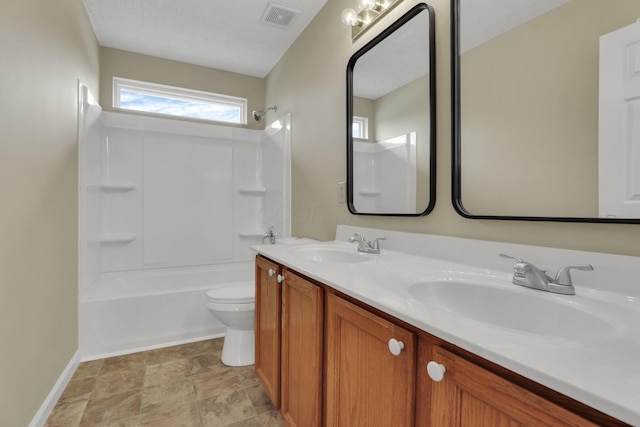 bathroom featuring toilet, baseboards, visible vents, a sink, and double vanity