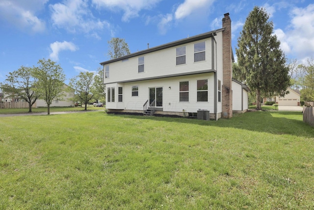 back of house featuring a chimney, entry steps, central AC, and a yard