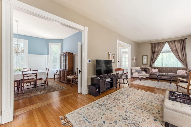 living room with a wainscoted wall, hardwood / wood-style flooring, and a notable chandelier