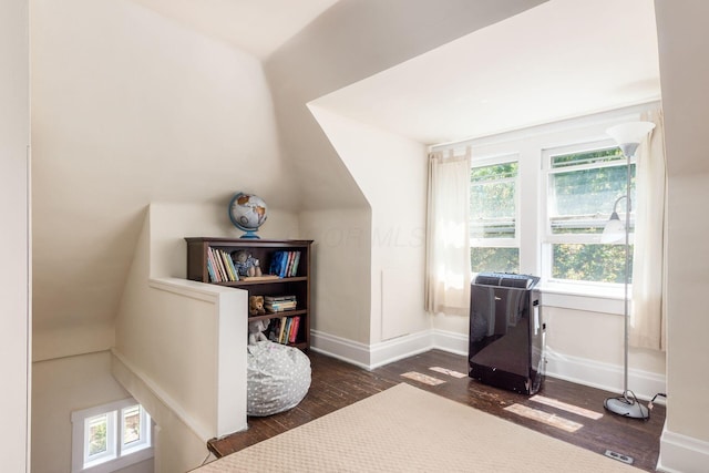 interior space with baseboards, vaulted ceiling, and dark wood-style floors