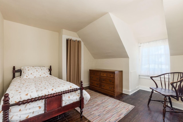 bedroom with baseboards, lofted ceiling, and hardwood / wood-style flooring