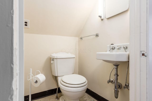 bathroom with toilet, baseboards, and lofted ceiling