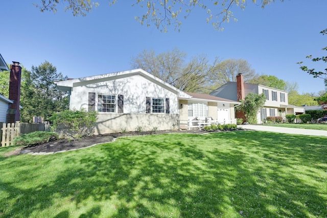 ranch-style house featuring fence and a front lawn