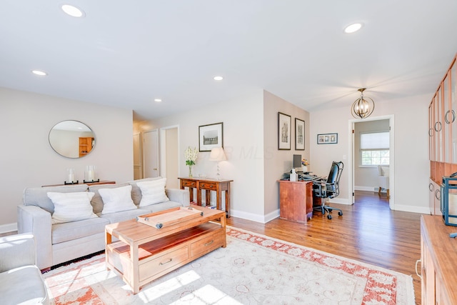 living room featuring recessed lighting, baseboards, and light wood finished floors