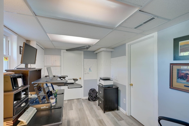 office space featuring visible vents, a paneled ceiling, and wood finished floors