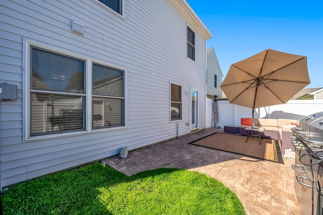 exterior space featuring a patio, outdoor lounge area, and fence