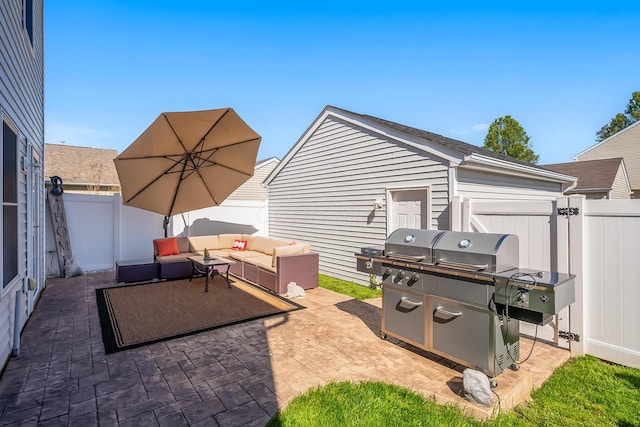 view of patio featuring a fenced backyard, an attached garage, an outdoor living space, and grilling area