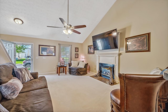 carpeted living area with a premium fireplace, a ceiling fan, vaulted ceiling, and a healthy amount of sunlight