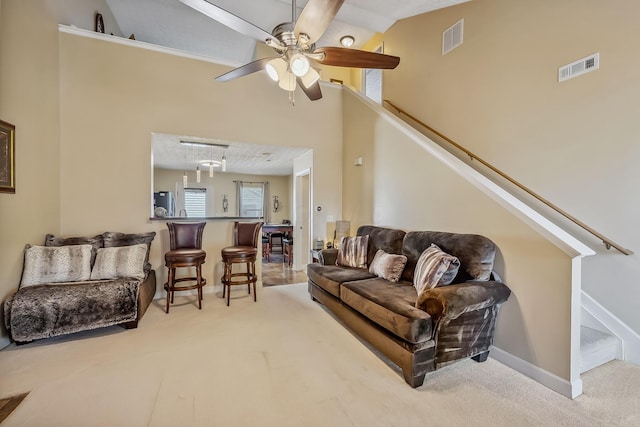carpeted living room featuring a ceiling fan, baseboards, visible vents, and high vaulted ceiling