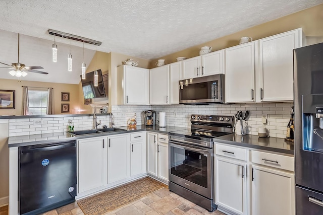 kitchen featuring decorative backsplash, dark countertops, white cabinets, a sink, and stainless steel appliances