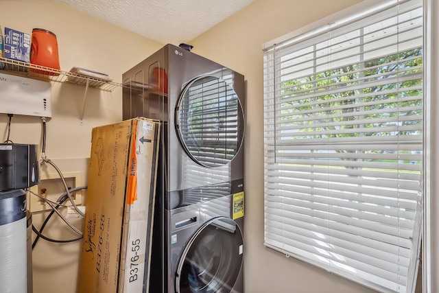 clothes washing area featuring laundry area and stacked washer / dryer