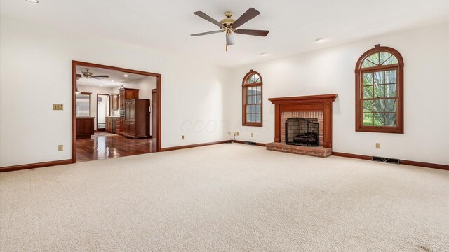 unfurnished living room featuring carpet floors, a ceiling fan, baseboards, and visible vents