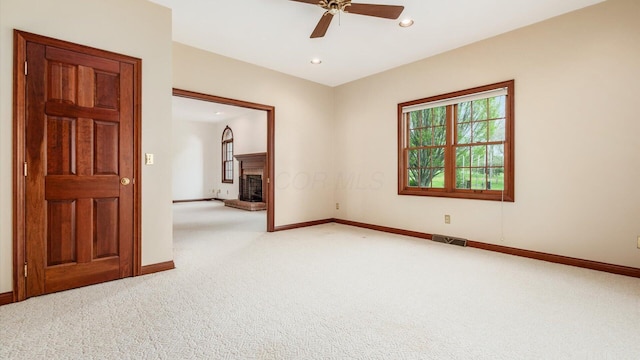 empty room featuring visible vents, a ceiling fan, carpet, and baseboards