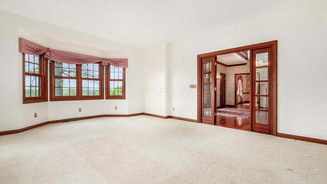 spare room featuring baseboards, carpet, and visible vents