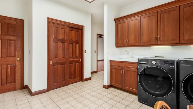 laundry room featuring a sink, baseboards, washing machine and dryer, and cabinet space