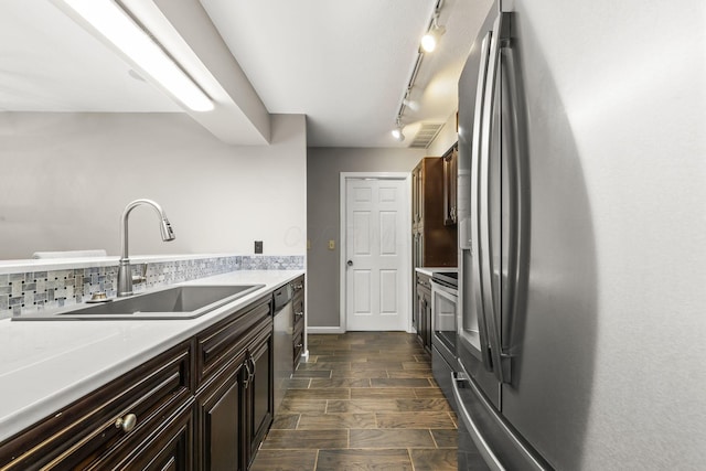 867 Red Oak Trl, Mansfield, OH 44904 - kitchen with dark brown cabinetry, a sink, light countertops, rail lighting, and stainless steel appliances