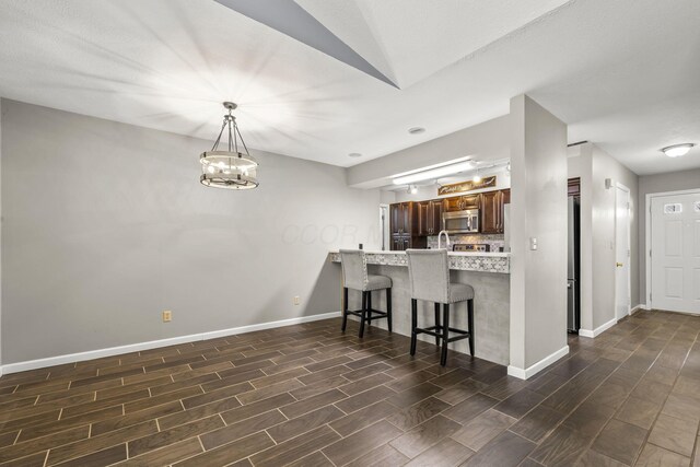 867 Red Oak Trl, Mansfield, OH 44904 - kitchen with light countertops, a kitchen breakfast bar, baseboards, and wood tiled floor
