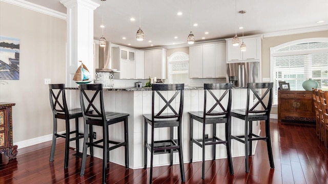 3555 Sellers Dr NE, Millersport, OH 43046 - kitchen featuring wall chimney exhaust hood, stainless steel fridge with ice dispenser, a breakfast bar, dark wood-style flooring, and white cabinetry