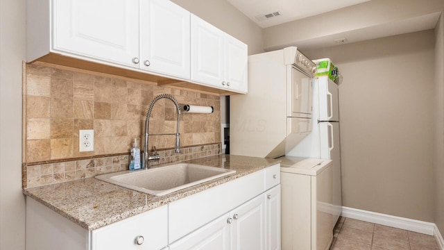 3555 Sellers Dr NE, Millersport, OH 43046 - laundry area with baseboards, light tile patterned flooring, and stacked washer / drying machine
