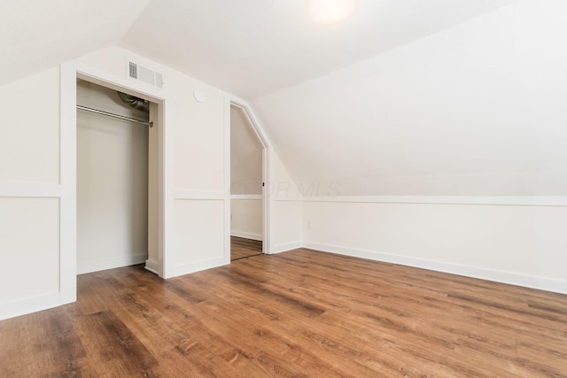 bonus room with visible vents, baseboards, lofted ceiling, and wood finished floors