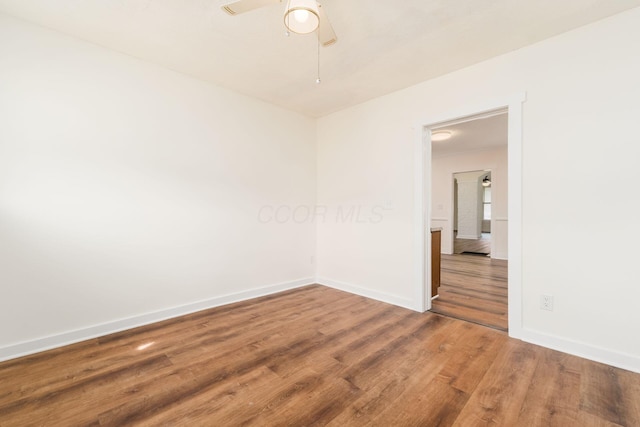 empty room with a ceiling fan, baseboards, and wood finished floors