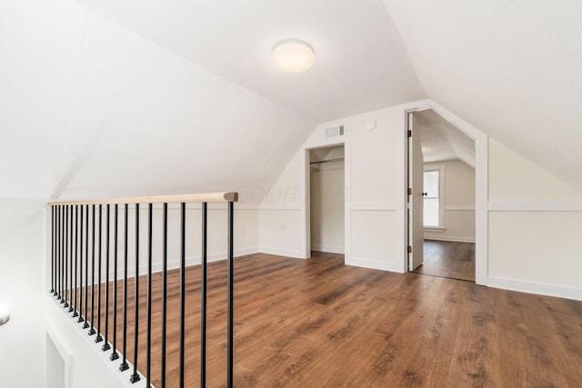 additional living space featuring visible vents, baseboards, wood finished floors, and vaulted ceiling
