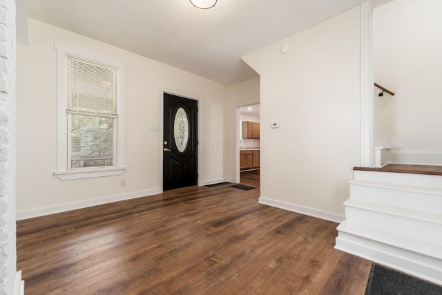 entrance foyer with baseboards, stairs, and dark wood-style floors