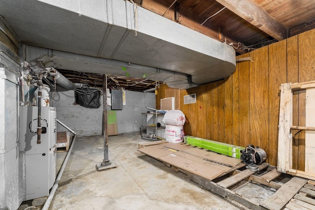 unfinished below grade area with electric panel and wooden walls
