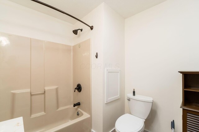 bathroom with baseboards, washtub / shower combination, and toilet
