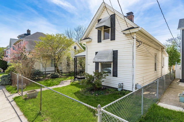 exterior space with a yard, a chimney, and a fenced backyard